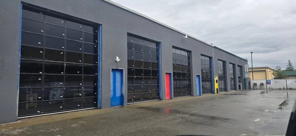 Row of full-view glass commercial garage doors